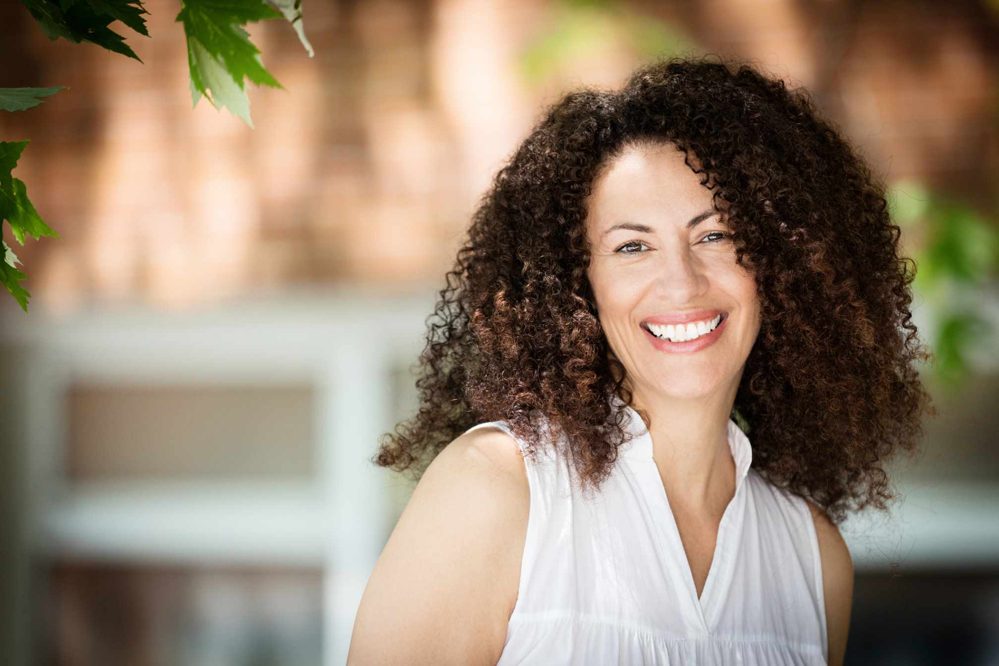 Mujer sonriente con sembalnte de bienestar y confianza.